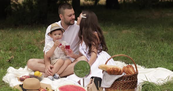 Woman in a Sundress Kissing Her Spouse and Son