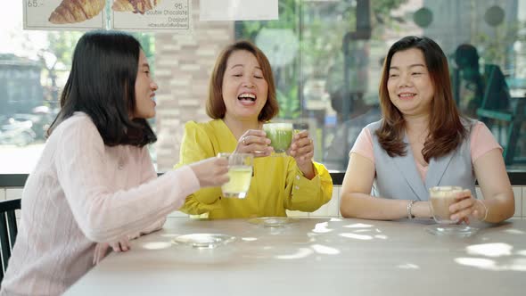 Group of middle-aged Asian female friends having fun and chatting in a cafe