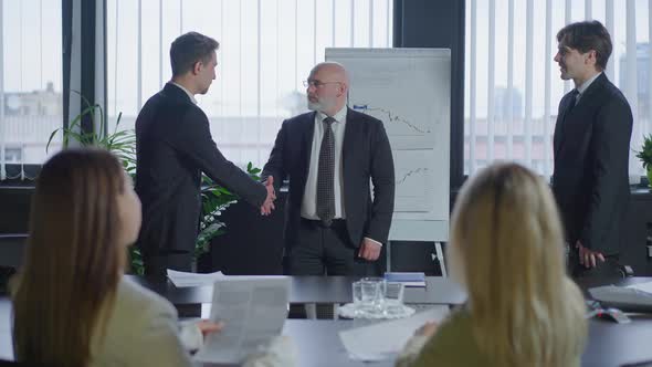 Business Partners Shaking Hands Making Good Deal in Office Boardroom alt