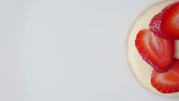 Cheesecake with Strawberries Rotates on an Isolated on White Background alt