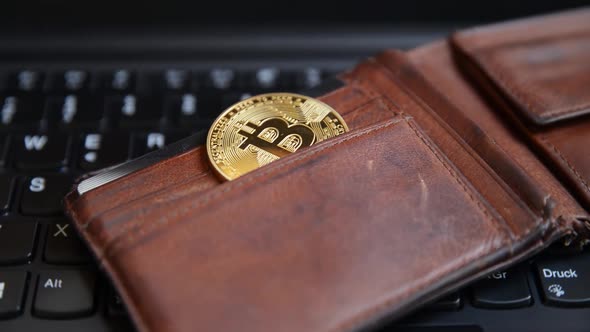 Closeup of a bitcoin wallet on a black keyboard.