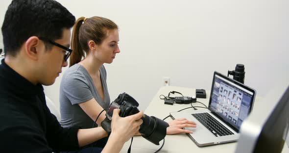 Male photographer reviewing captured photos in his digital camera alt