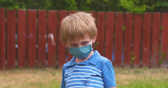 Cute, young boy wearing a face covering to prevent the spread of coronavirus disease. alt
