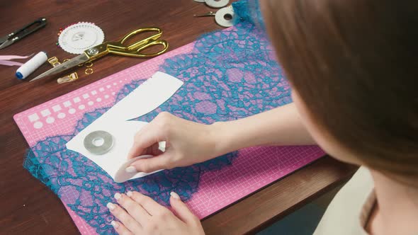 Woman Dressmaker Making Chalk Marks on Guipure Fabric Closeup Working in the Atelier alt