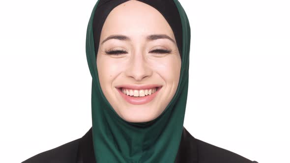 Portrait of Positive Arabic Woman in Traditional Hijab Posing Looking on Camera and Laughing Over alt