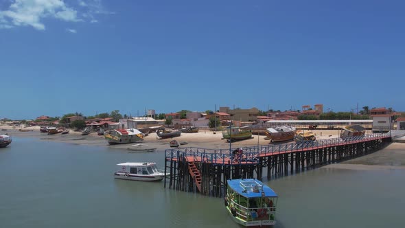 Orbiting Over Wooden Pier With Boats Mooring During Sunny Day In Natal, Brazil. Aerial Drone Shot alt