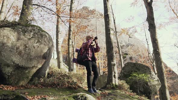 Young Bearded Man Photographing Cliffs High in the Mountains  Autumn Sunny Day alt