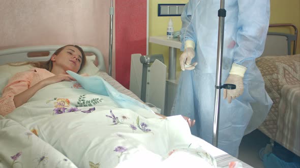 Female Nurse Checking Dropper with Medication, Rendering First Aid To Patient alt