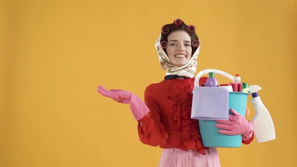 A Happy Woman with a Bucket of Cleaning Products Points to a Copy of the Space