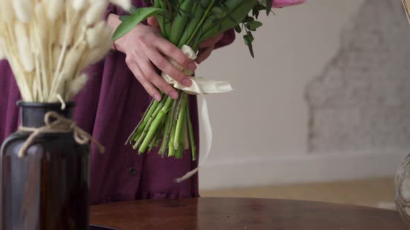 Woman Florist Puts a Finished Bouquet on the Table. alt