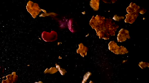 Corn Flakes with berries falling to the ground. Studio shot filmed from below with two hits. alt