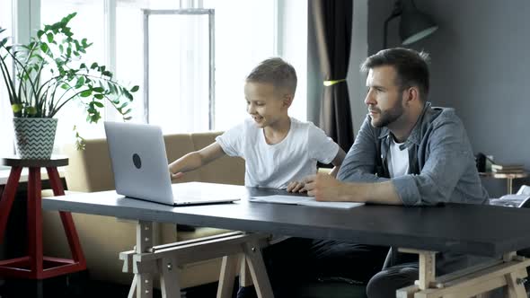 Smiling son thanking father for his help in doing homework at home