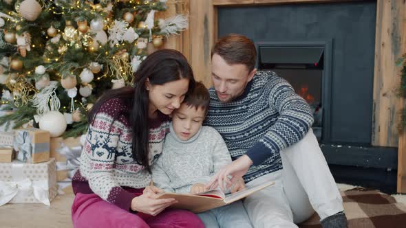 Slow Motion of Woman, Man and Boy Reading Book and Discussing Story on New Year's Day alt