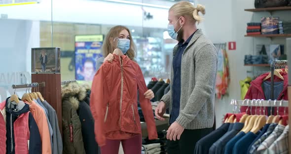 Young Caucasian Couple Shopping in Clothing Shop During Black Friday Sales on Coronavirus Pandemic alt