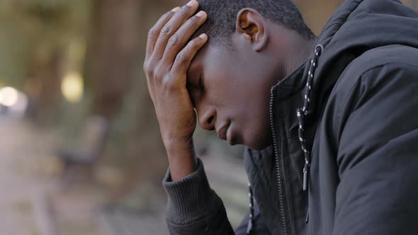 Desperate upset Young american African Man In The Park.job Loss,depression alt