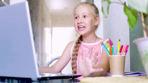 Caucasian Girl Speaking to Online Teacher During Distance Education on Laptop