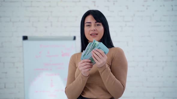 Happy woman with money. Portrait of cheerful young woman holding money banknotes alt
