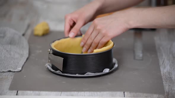 The Cook Puts the Dough in a Form for Making a Pie
