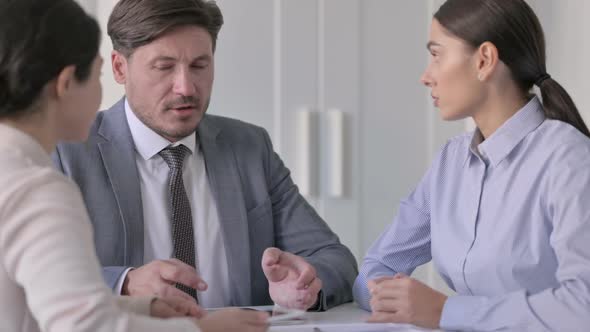 Middle Aged Businessman Talking to Female Colleagues in Office alt