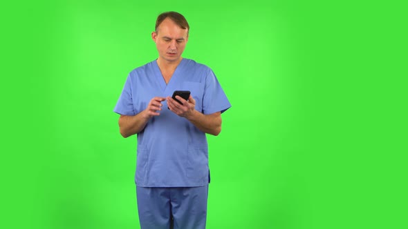 Medical Man Angrily Texting on Him Phone. Green Screen alt