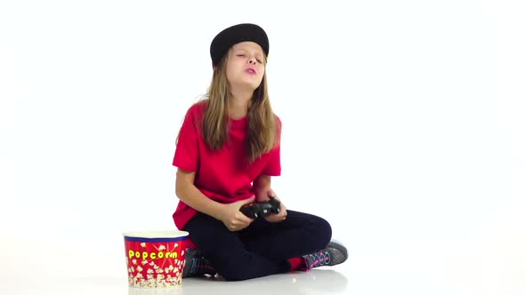 Teen Plays Joystick in Online Game, Eats Popcorn. Slow Motion alt