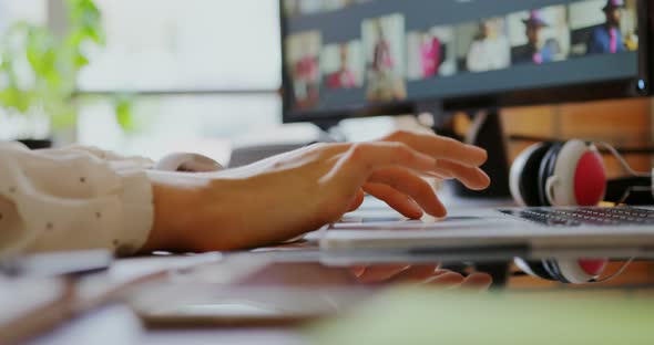 Female graphic designer using laptop in a modern office 4k
