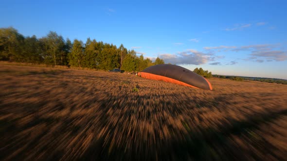 Fast Low flying above sloping field at beautiful summer sunrise