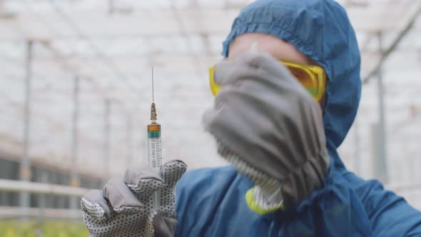 Agro Engineer with Syringe in Greenhouse alt