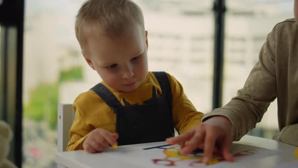 Siblings Spending Time Together at Home. Brothers Sitting Table with Board Games alt
