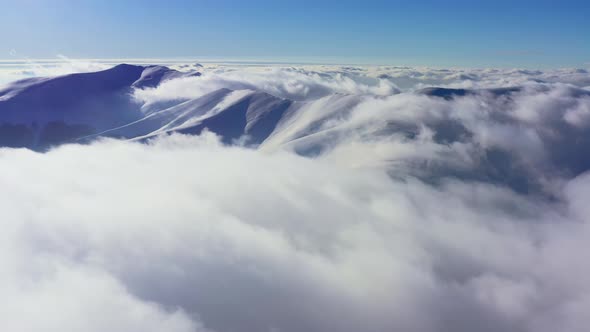 An Extraordinary Mountain Valley Covered with Fluffy Clouds at Winter Sunset alt