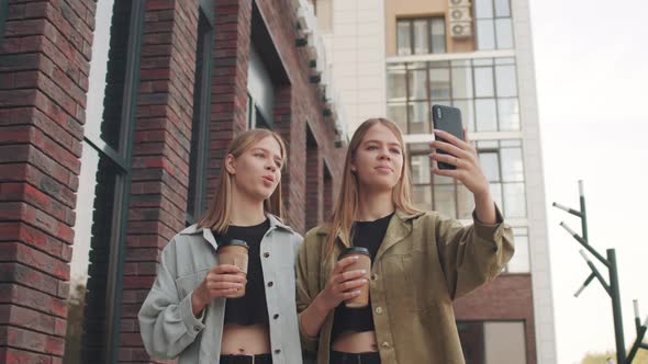 Happy Twin Sisters Walking and Filming on Mobile Phone alt