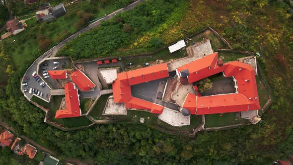Aerial Top Down View of Medieval Castle on Mountain in Small European City at Cloudy Autumn Day alt