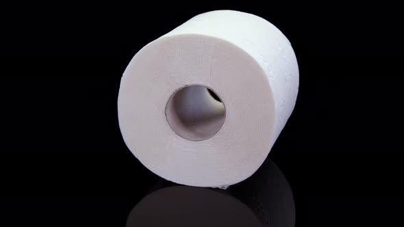 Toilet paper roll rotating on a black background.