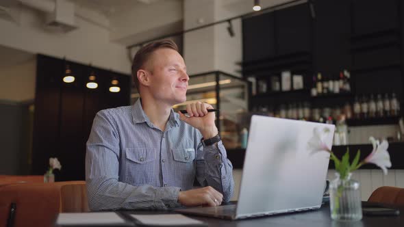 Thoughtful Serious Young Man Student Writer Sit at Home Office Desk with Laptop Thinking of alt