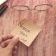 Putting Never Give Up Written on Stick Note on Table - VideoHive Item for Sale