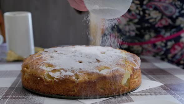 Woman Sprinkling Domestic Apple Pie with Powdered Sugar