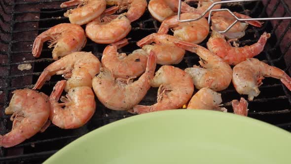 Closeup of the Large King Prawns Taken From the Grill Grid with Kitchen Tongs alt