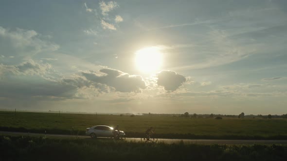 Two Cyclists are Riding on the Highway alt