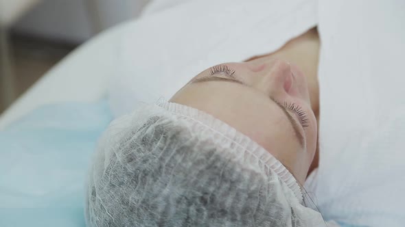 Cosmetician Gloves Making Face Lifting Injection To Area Around Eyes alt