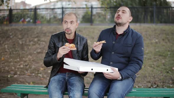 Two Men on a Park Bench Eating a Takeaway Pizza From the Box