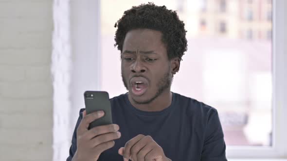Sad African Man Shocked By Loss on Smartphone alt