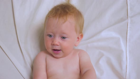 Baby girl drinking water from bottle. Nutrition for babies. alt