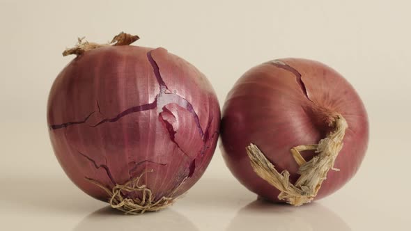 Tilting over onion with red skin and white flesh close-up 4K 2160p 30fps UltraHD footage - Organic v alt