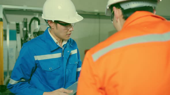 Male Asian engineer professional  having a discussion standing consult cnc machine alt