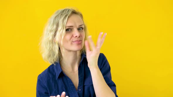 Crazy Cheerful Blonde Girl Licks Fingers After Tasty Eating Isolated on Yellow Studio Background alt
