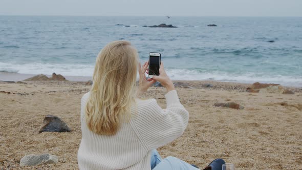 Young Woman Is Taking Photos of Sea