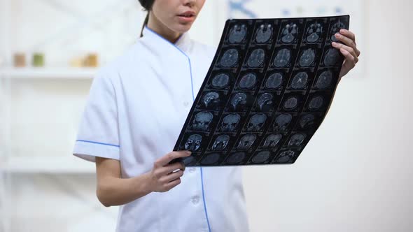 Experienced Neurosurgeon Looking at Brain X-Ray, Upset With Examination Result alt
