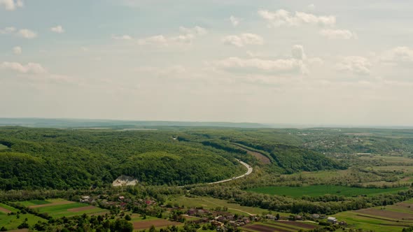 Aerial View Several Truck with Cargo Semi Trailer and Several Cars Moving on Road in the Mountains. alt