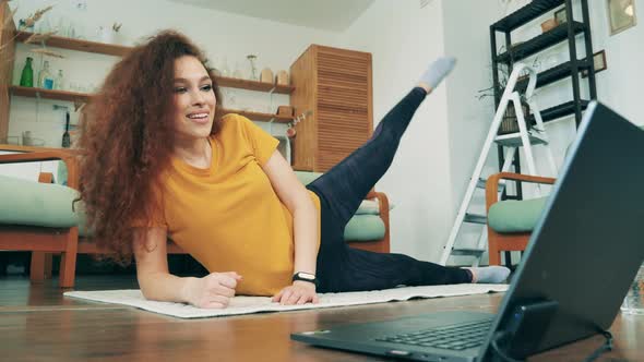 Smiling Woman Exercises on a Mat at Home During Quarantine. Remote Learning Concept. alt