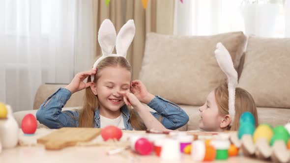 a Happy Little Girls with Rabbit Ears Celebrate Easter and Play Hide and Seek alt